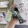 Hand holding a stylish perodua bezza key cover with a cute bear charm and fashion strap, designed for toyota and daihatsu car...