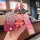 A hand holds a pink ford focus fiesta key cover (2009–2013) with a cute bear charm and matching strap, showcasing its sleek d...