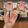 A hand holds a pink kia key cover with a silver kia logo and a decorative keychain, showcasing the front view of the sleek de...