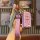 A hand holds a pink foton tuoyano key cover shell with a quilted leather strap and a diamond-encrusted keychain, designed for...