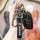 A hand holds a roewe rx5 key cover, featuring a sleek black leather sleeve with the roewe logo and rfid-blocking technology, ...