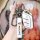 A hand holds a roewe rx5 key cover, showcasing its sleek white leather design with rfid-blocking features. the keychain inclu...