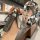 A hand holds a sleek wuling key cover with a leather strap, showcasing its front view in a modern café setting. the key fob i...