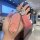 A hand holds a stylish aito m9 key cover with a pink leather sleeve and silver accents, featuring rfid protection and elegant...