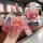 A hand holds a ford key fob in a pink gradient cover, featuring a cute bear charm and a fashion strap, with a close-up showin...