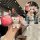Hand holding a wuling binguo key cover with a cute bear charm, featuring a front view of the pink design and gradient strap i...