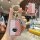 Elegant pink mazda 3 key cover with gold accents and a mercedes-benz emblem, featuring a decorative keychain and detailed fro...