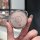 A hand holds a sleek, silver aya premium key cover for nio u/s/l/v/gt (2023–2024), featuring a textured pink surface with a m...
