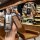 A hand holds a sleek aion y key cover with a premium leather strap, showcasing its front view in a modern café setting. the k...