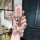 A hand holds a stylish wuling hongguang mini ev key cover for the 2022 macaron edition, featuring a pink textured design with...