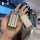 A hand holds a stylish tank 300 key cover, featuring a glittery silver design with a leather tag and sparkling charm, perfect...