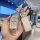 A hand holds a stylish peugeot 308 key cover featuring a ds badge, adorned with sparkling embellishments and a matching leath...