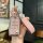 A hand holds a stylish mg6 pro key cover, featuring a glittery pink design with a leather strap labeled fashion, offering pre...