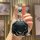 A hand holds the sleek jetour traveler 2024 key cover, showcasing its black and silver design with a modern, hexagonal shape ...
