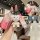 A hand holds a wuling hongguang mini ev key cover with a gradient pink design and a cute bear charm, featuring a front view c...