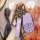 A hand holds a stylish nio es6 key cover, featuring a sleek purple leather design with a matching strap and functional lock/u...