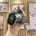 A hand holds a sleek black vinfast vf8 vf3 premium key cover with a stylish bear-shaped keychain and a patterned strap, set a...