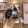 A hand holds a vinfast vf8/vf3 remote key cover with a sleek leather strap and a cute bear-shaped keychain, set against a sty...