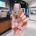 A hand holds a toyota avalon key fob in a pink leather cover, adorned with a decorative bow and rhinestones, set against a mo...