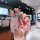 A hand holds a sleek, pink vw key cover for models like passat, tiguan, and golf 7, featuring a premium leather strap and a s...