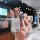 A hand holds a sleek, silver buick key cover for excelle, verano, regal & gl8, featuring a white braided lanyard and a decora...
