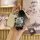 A hand holds a pandect x3190/dxl-1840l key wallet with a sleek white design, accompanied by a cute bear-shaped keychain and a...