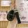 A hand holds a sleek black gac gs3 key cover with a leather strap and decorative silver charm, showcasing its elegant design ...