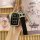A hand holds a proton key cover tpu protector for genesis & kia remotes, featuring a sleek black design with a diamond-embell...