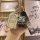 A hand holds a sleek, metallic chery kaiyi xuanjie 1.5l cvt smart key cover with a cute bear charm and a stylish wrist strap,...