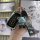 A hand holds a sleek black lexus smart key cover with a metallic finish, featuring a cute bear-shaped keychain and a matching...