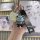 A hand holds a toyota fj cruiser prado 3-button key cover with a stylish gray bear charm and a fashion strap, set against a m...