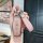 A hand holds a tengshi d9/n7/n8 key cover, featuring a pink glittery design with a leather strap and a silver f charm, showca...