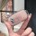 A hand holds a perodua toyota key cover, showcasing its sleek design with a glittery pink finish and a prominent logo. this p...
