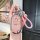 A hand holds a pink benteng xiaoma 2024 key cover with a cute horse design, featuring a braided pink strap and a shiny metall...