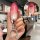 Hand holding a benteng t77 key cover with a gradient pink design and cat-themed keychain, shown in front view.