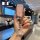 A hand holds a pink, glittery j model key cover for the changan cs75 plus, featuring a diamond-encrusted key ring, set agains...