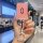 A hand holds a stylish aito m5/m7 leather key cover with a pink textured design and a sparkling ring, set against a modern ca...