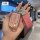 A hand holds a baojun key cover with a glittery pink design and a matching leather tag, showcasing its elegant and protective...