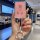 A hand holds a pink hongqi hs5 hs7 nfc card key cover with a sparkling design and a decorative keychain, set against a modern...