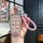 Elegant pink glitter key cover for hyundai tucson l 5th gen, featuring a braided strap and decorative charm, offering stylish...