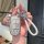 A hand holds a jeep leather key cover for compass, cherokee, and renegade, featuring a sleek design with a braided white stra...
