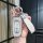 A hand holds a sleek, silver geely key cover with a leather strap labeled fashion, designed for models like emgrand gs and bo...