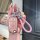 A hand holds a pink volkswagen key cover for models like lavida, sagitar, and bora, featuring a braided strap and decorative ...