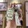 Hand holding a cheetah cs10 key cover with leather strap and good luck charm, showcasing premium design and protection for ca...