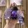 A hand holds a purple fiat 500 key cover with a sleek leather design, accompanied by a cute bear charm and a stylish wrist st...