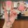A hand holds a pink toyota key cover with a gradient design, featuring a front view of the key fob and a decorative keychain....