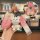 A hand holds a pink bmw blade key cover for 3/5 series & x1-x5, featuring a performance logo and a cute bear charm with blue ...
