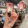 A hand holds a pink and silver buick key cover for verano gt, regal, lacrosse, and encore, featuring a cat-shaped keychain an...