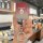 A hand holds the ora iq key cover 2024, a sleek leather remote sleeve with a gradient red-to-silver design and a decorative k...