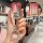 Hand holding a sleek, gradient red tank 300 key cover with a cat-shaped keychain, showcasing the front view of the key fob bu...